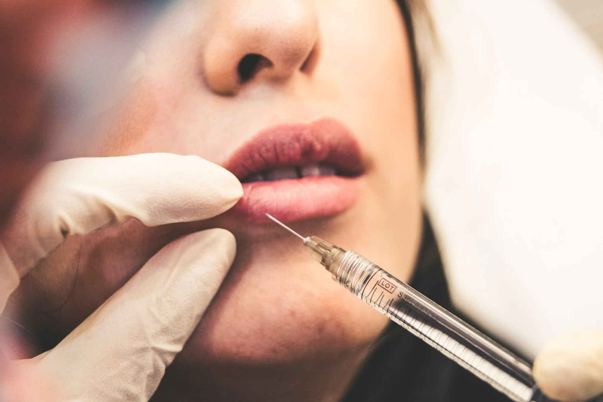 Woman receiving a cosmetic lip injection | Mayfield Clinic